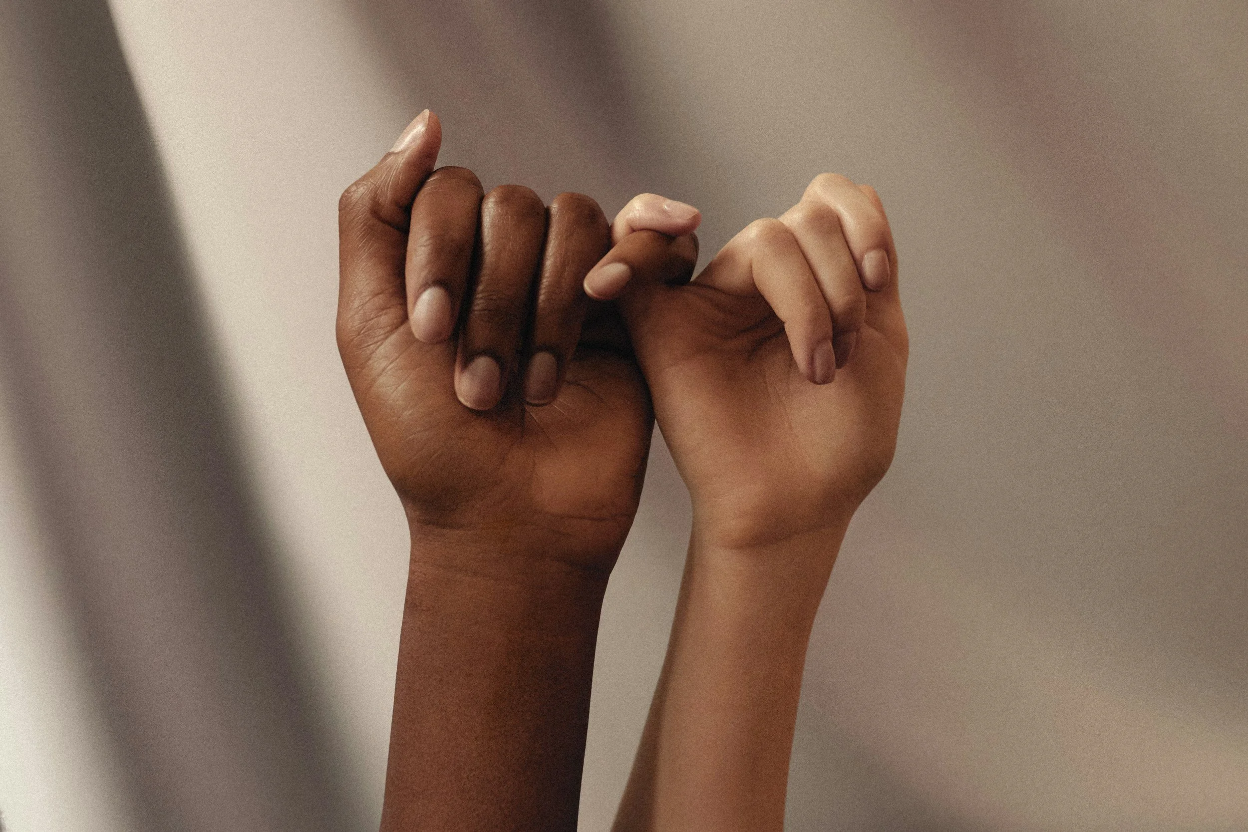 two hands with their pinkies intertwined